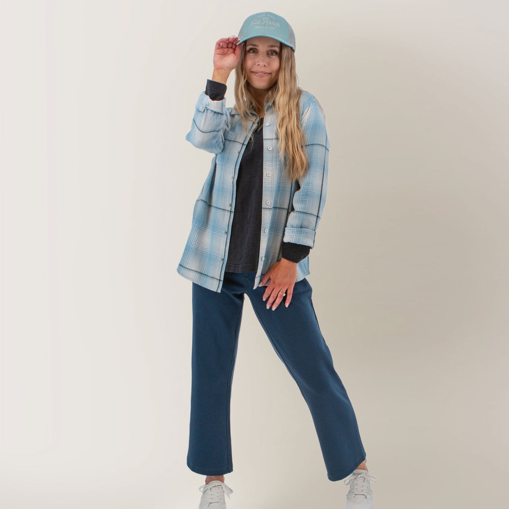 Old Ranch faded denim plaid blouse front view: light blue plaid button-up worn open over a white turtleneck with dark cargo pants