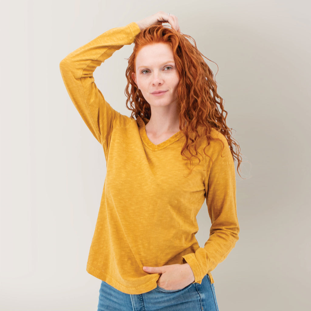 Old Ranch pomegranate organic cotton V-neck T-shirt, front view on model with embroidered neckline, long sleeves and blue jeans
