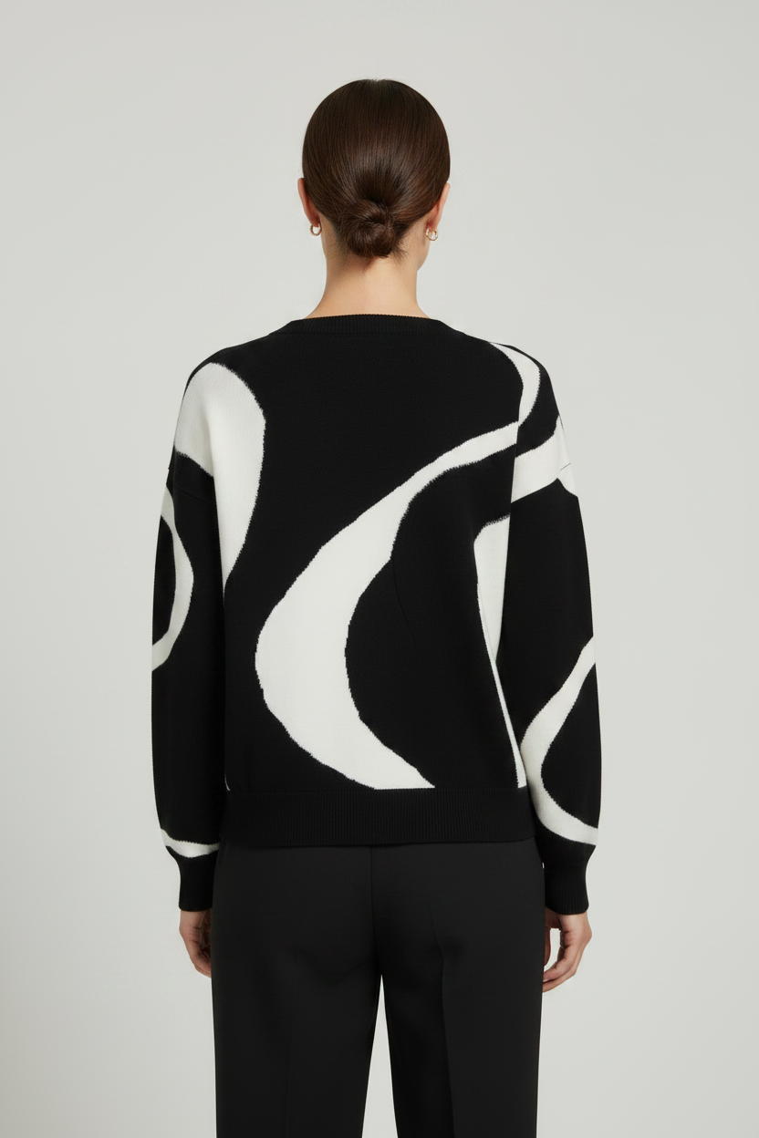 CS the Label black and white color-blocked V-neck sweater with a bold swirl pattern, modeled on a woman from the front