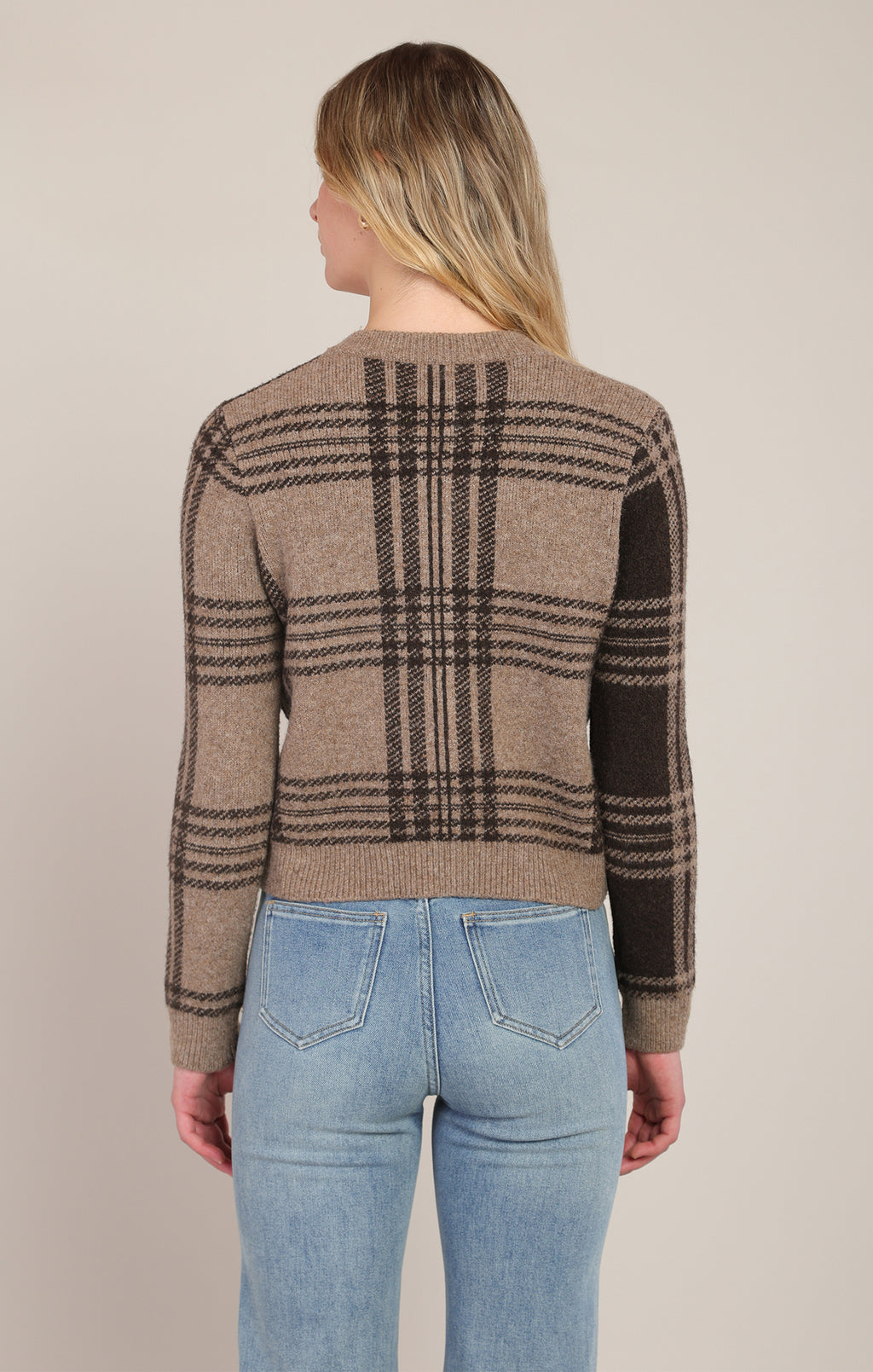 Front close-up of model wearing Room 34 taupe and brown plaid button-front cardigan with light-wash jeans