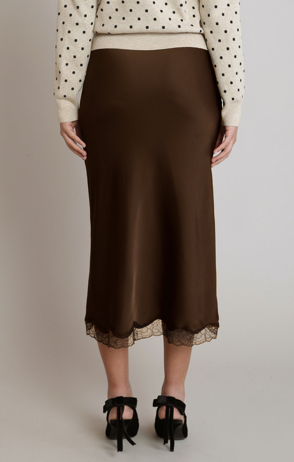  Dex satin midi skirt with a softly flared silhouette and scalloped lace hem, styled with a cream cardigan and black heels